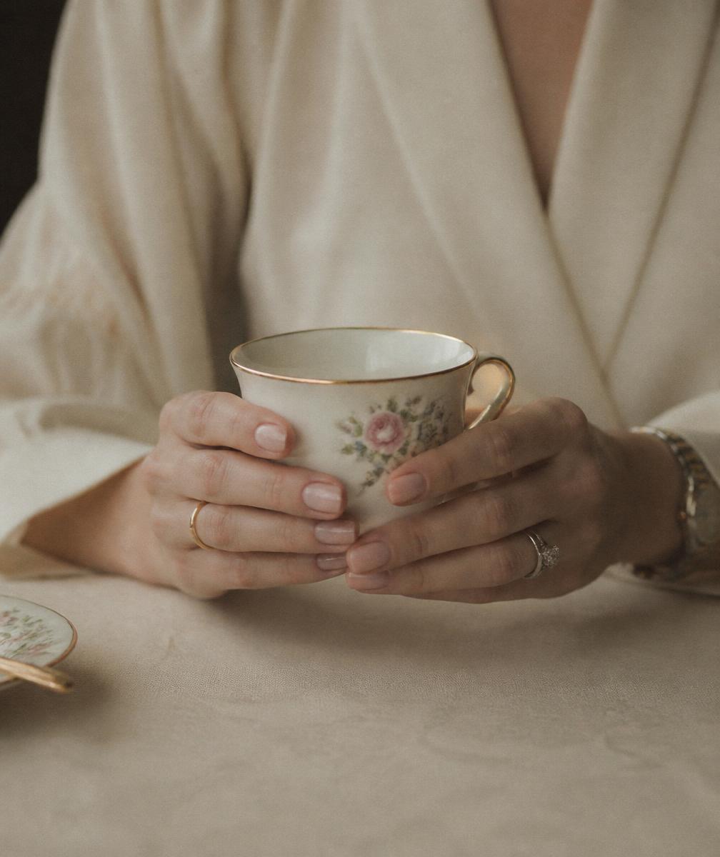 Hands holding a porcelain teacup